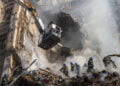 Firefighters work after a drone fired on buildings in Kyiv, Ukraine, Monday, Oct. 17, 2022. Waves of explosive-laden suicide drones struck Ukraine's capital as families were preparing to start their week early Monday, the blasts echoing across Kyiv, setting buildings ablaze and sending people scurrying to shelters. (AP Photo/Roman Hrytsyna)