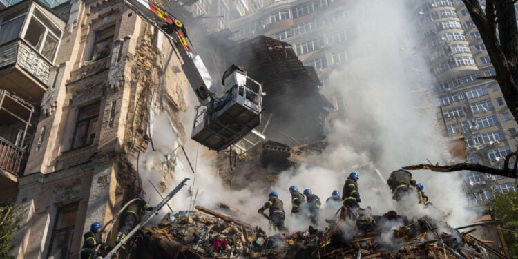 Firefighters work after a drone fired on buildings in Kyiv, Ukraine, Monday, Oct. 17, 2022. Waves of explosive-laden suicide drones struck Ukraine's capital as families were preparing to start their week early Monday, the blasts echoing across Kyiv, setting buildings ablaze and sending people scurrying to shelters. (AP Photo/Roman Hrytsyna)