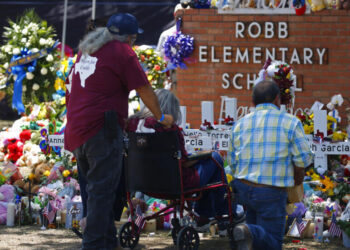 People pay their respects at a memorial outside Robb Elementary School to honor the victims killed in this week's school shooting in Uvalde, Texas Saturday, May 28, 2022. (AP Photo/Dario Lopez-Mills)