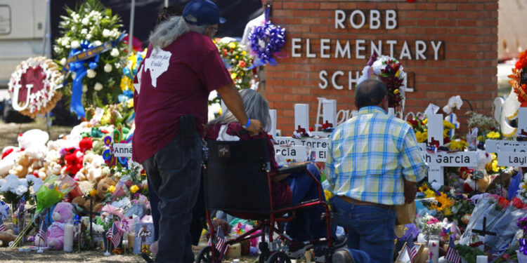 People pay their respects at a memorial outside Robb Elementary School to honor the victims killed in this week's school shooting in Uvalde, Texas Saturday, May 28, 2022. (AP Photo/Dario Lopez-Mills)