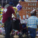 People pay their respects at a memorial outside Robb Elementary School to honor the victims killed in this week's school shooting in Uvalde, Texas Saturday, May 28, 2022. (AP Photo/Dario Lopez-Mills)